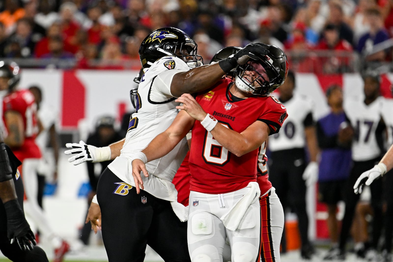 Baltimore Ravens defensive tackle Nnamdi Madubuike (92) is fouled against Tampa Bay Buccaneers quarterback Baker Mayfield (6) during the first half of an NFL football game, Monday, Oct. 21, 2024, in Tampa, Fla. (AP Photo/Jason Behnken)