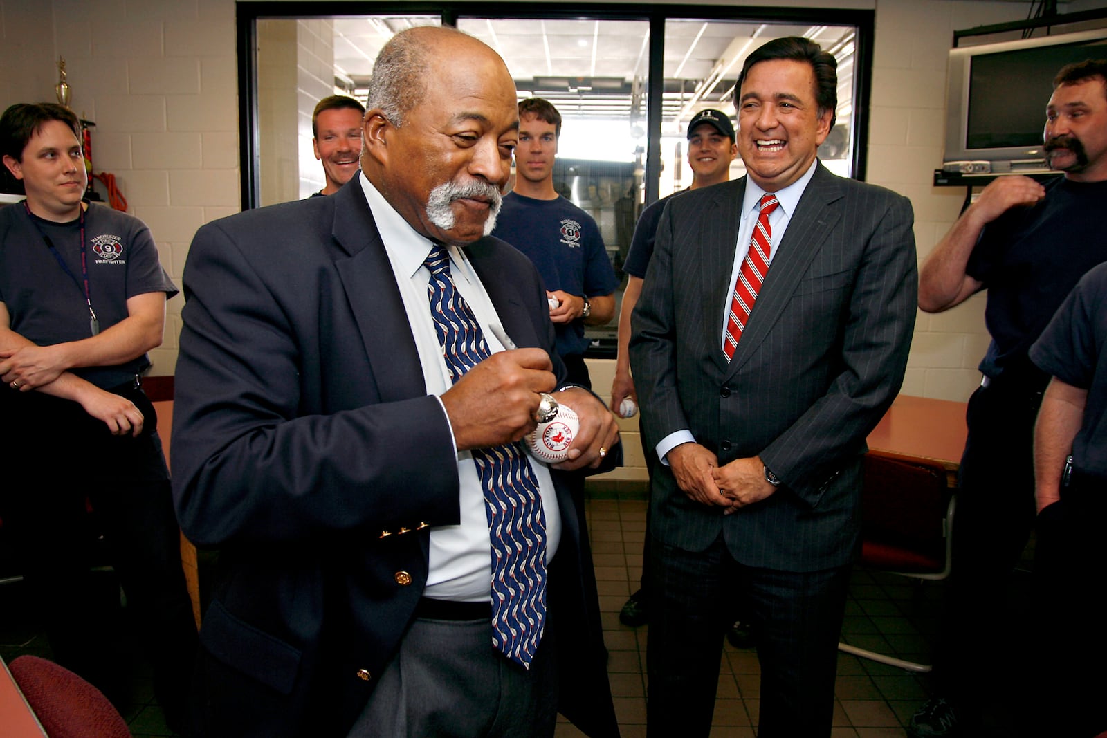 FILE - Former major league baseball player Luis Tiant signs baseballs for firefighters at the Manchester Fire Department in Manchester, N.H., as presidential hopeful, New Mexico Gov. Bill Richardson, right, watches, Monday, May 7, 2007. (AP Photo/Cheryl Senter, File)