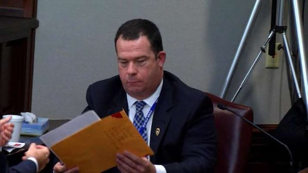 Cobb County lead detective Phil Stoddard looks through phone call and texting records during his testimony in the murder trial of Justin Ross Harris at the Glynn County Courthouse in Brunswick, Ga., on Monday, Oct. 24, 2016. (screen capture via WSB-TV)