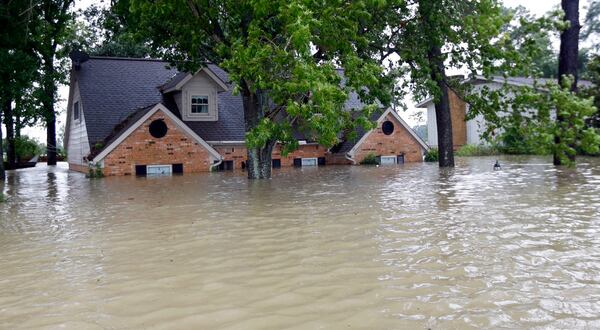 A home is surrounded by floodwaters from Tropical Storm Harvey on Monday, Aug. 28, 2017, in Spring, Texas. Homeowners suffering from Harvey flood damage are more likely to be on the hook for losses than victims of prior storms, a potentially crushing blow to personal finances and neighborhoods along the Gulf Coast. Experts say far too few homeowners have flood insurance, just two of ten living in Harveyâs path of destruction. (AP Photo/David J. Phillip)