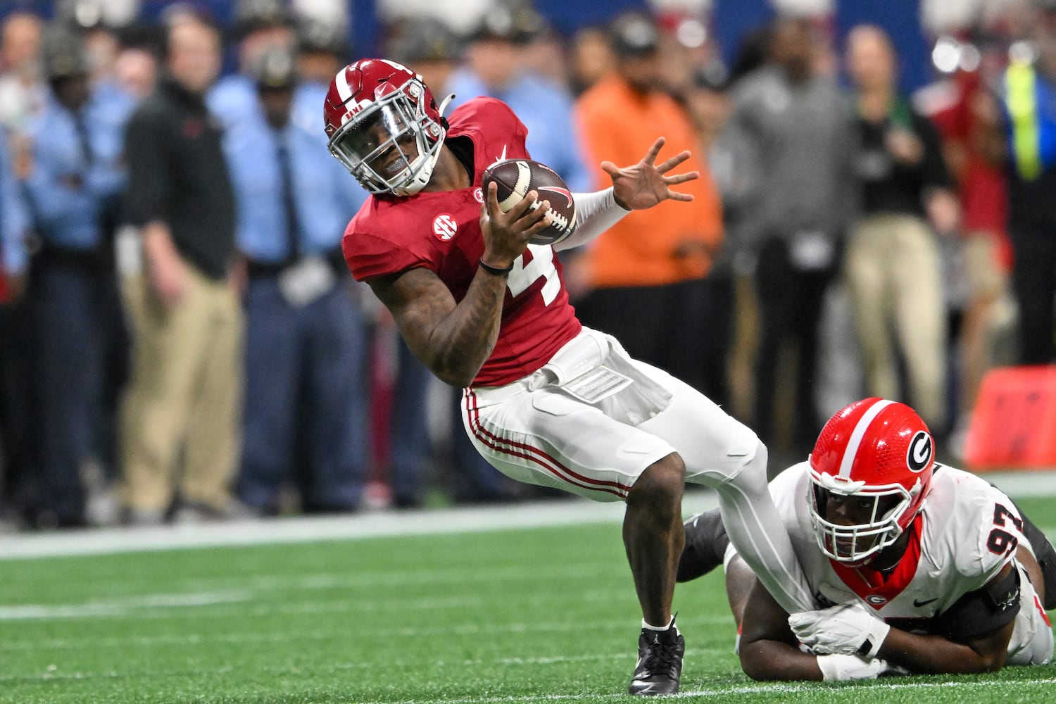 Georgia Bulldogs defensive lineman Warren Brinson (97) tackles Alabama Crimson Tide quarterback Jalen Milroe (4) during the first half of the SEC Championship football game at the Mercedes-Benz Stadium in Atlanta, on Saturday, December 2, 2023. (Hyosub Shin / Hyosub.Shin@ajc.com)