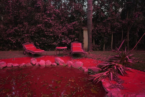 FILE - Fire retardant covers a backyard in Mandeville Canyon during the Palisades Fire, Jan. 11, 2025, in Los Angeles. (AP Photo/Eric Thayer)