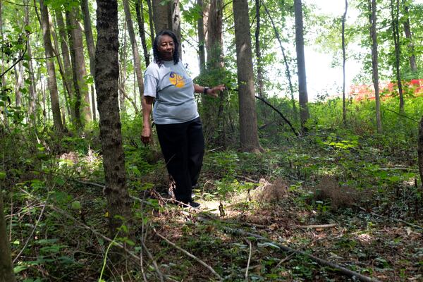 Francine Wilkins looks for a relative's grave in the Old Ebenezer Cemetery in Marietta, which she is working to restore. Photographed on Friday, July 14, 2023. (Ben Gray / Ben@BenGray.com)