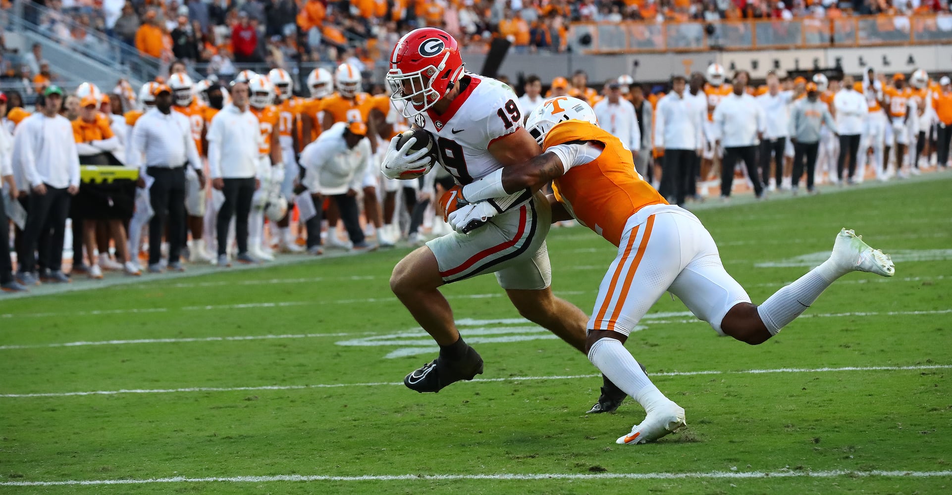 Georgia tight end Brock Bowers powers into the endzone past Tennessee defensive back Jaylen McCollough to take a 24-7 lead during the second quarter in a NCAA college football game on Saturday, Nov. 18, 2023, in Knoxville.  Curtis Compton for the Atlanta Journal Constitution