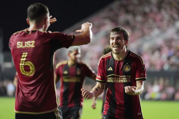 Atlanta United midfielder Bartosz Slisz (6) celebrates his goal with midfielder Saba Lobzhanidze (9) during the second half of their MLS playoff opening round soccer match against Inter Miami, Saturday, Nov. 9, 2024, in Fort Lauderdale, Fla. (AP Photo/Rebecca Blackwell)