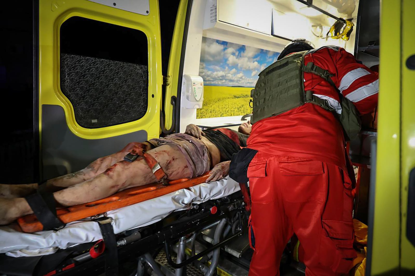 In this photo provided by Kharkiv City Administration, an ambulance evacuates an injured man after a multi-storey apartment building was hit by Russian attack in Kharkiv, Ukraine, late Wednesday, Oct. 30, 2024. (Kharkiv City Administration via AP)