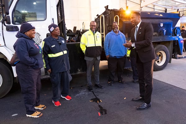 Mayor Andre Dickens jokes around with members of the "Pothole Posse" following a press conference at Lenox Square ahead of the holidays and winter weather on Monday, Dec. 2, 2024.   Ben Gray for the Atlanta Journal-Constitution