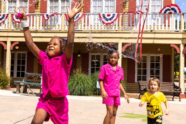 Kaylie, 5, (left) pops a bubble made by Booth at Stone Mountain  (Arvin Temkar / arvin.temkar@ajc.com)