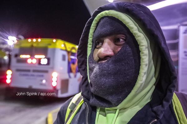 Benjamin Reyes is bundled up on his way to work at the Cobb Community Transit Center on South Marietta Parkway. Temperatures were in the mid-20s Wednesday morning across metro Atlanta. JOHN SPINK / JSPINK@AJC.COM