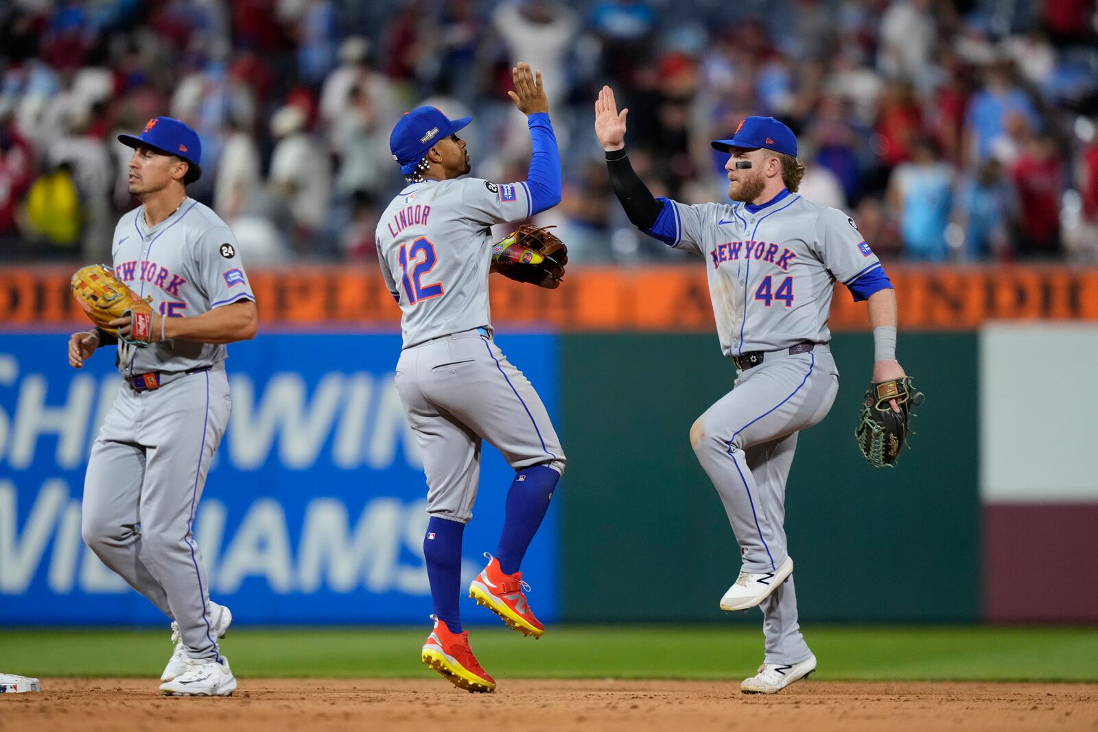 New York Mets' Harrison Bader (44), Francisco Lindor (12), and Tyrone Taylor celebrate after winning Game 1 of a baseball NL Division Series against the Philadelphia Phillies, Saturday, Oct. 5, 2024, in Philadelphia. (AP Photo/Matt Slocum)