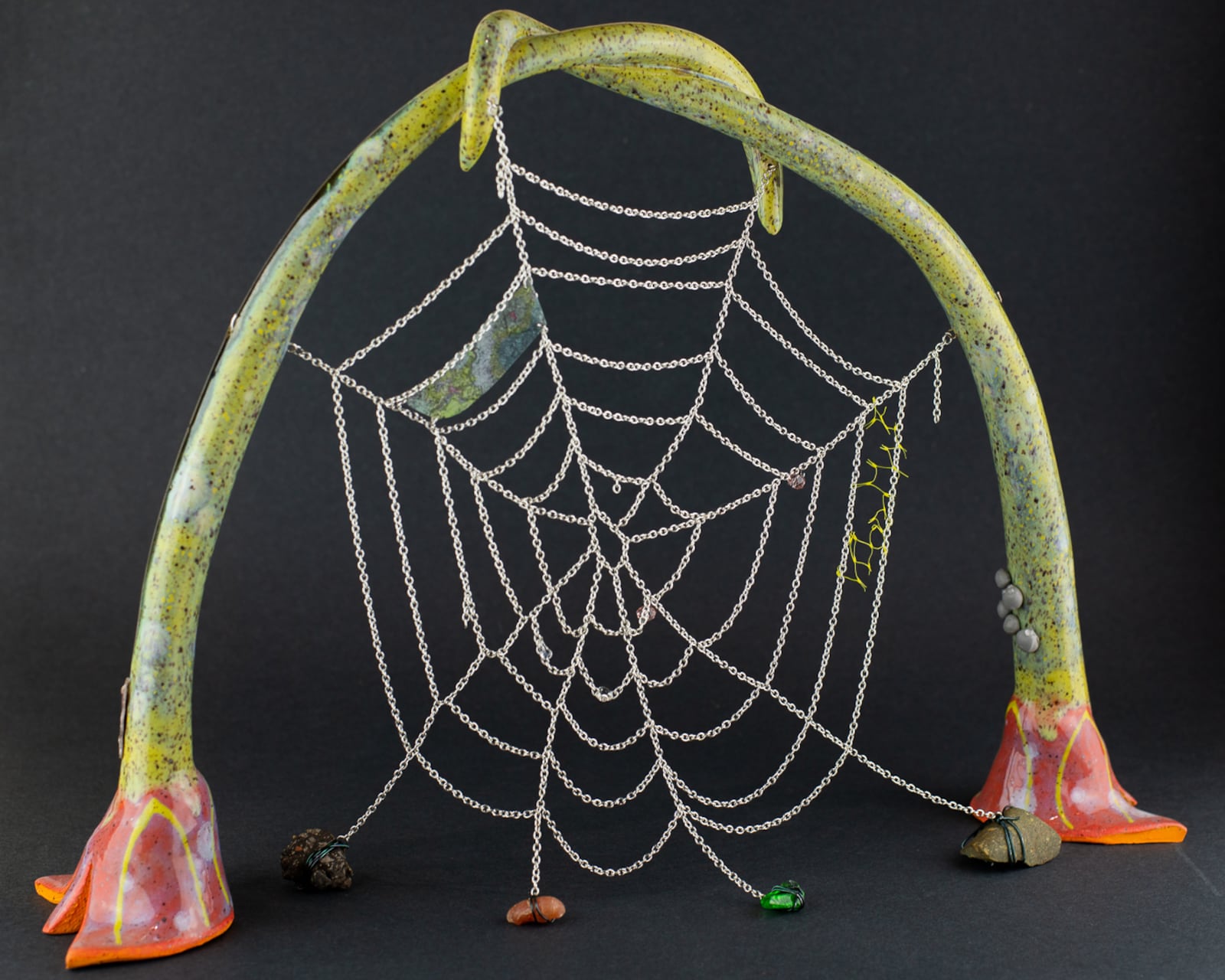 "A blood-full lily bulges over mountain massifs and valleys" in speckled stoneware and glaze, rock, asphalt, sea glass, aluminum chain, plastic beads, hand-colored transparency, wire, plastic netting, scales, sticker by Emily Llamazales is featured at Day and Night Projects. 
(Courtesy of Day and Night Projects)