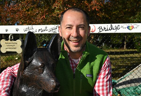 October 26, 2022 McDonough - Portrait of Dr. Humberto Fallas with a memorial of his German shepherd, Ace, near his office Fallas Family Vision in McDonough on Wednesday, October 26, 2022. The story is about a memorial that Dr. Humberto Fallas (called Peto) created for his German shepherd, Ace, that has become a kind of shrine for others who have lost their pets. About a dozen or so other pet owners have hung their pets' dogtags (and cat-tags) up at the site, memorializing animal friends who have passed away.(Hyosub Shin / Hyosub.Shin@ajc.com)