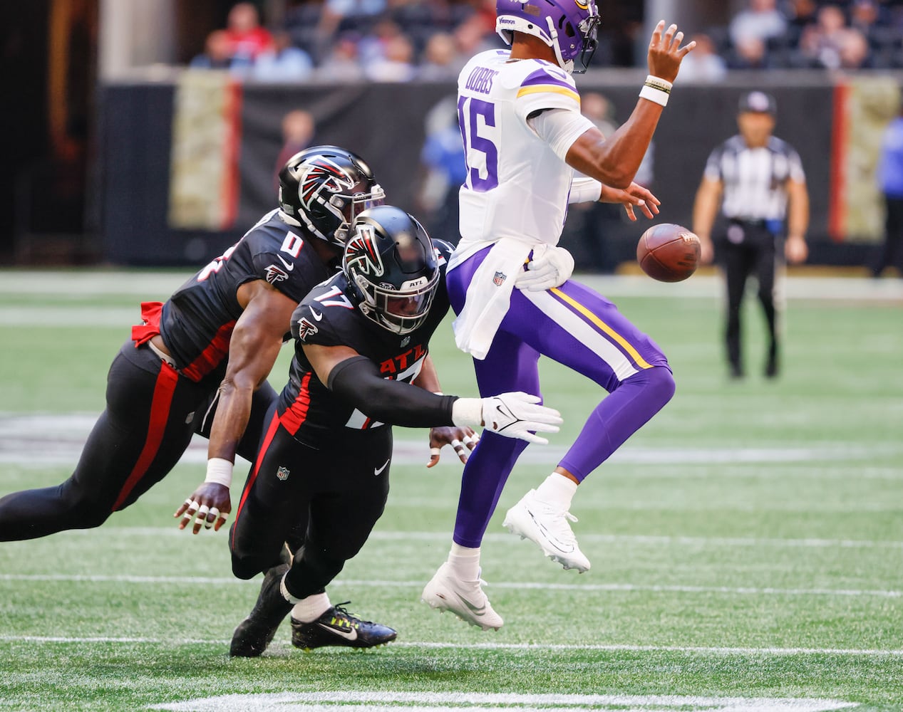 Atlanta Falcons linebacker Arnold Ebiketie (17) and linebacker Lorenzo Carter (0) force a fumble Minnesota Vikings quarterback Joshua Dobbs (15), recovered by the Falcons during the first half of an NFL football game In Atlanta on Sunday, Nov. 5, 2023 between the Atlanta Falcons and the Minnesota Vikings. (Bob Andres for the Atlanta Journal Constitution)