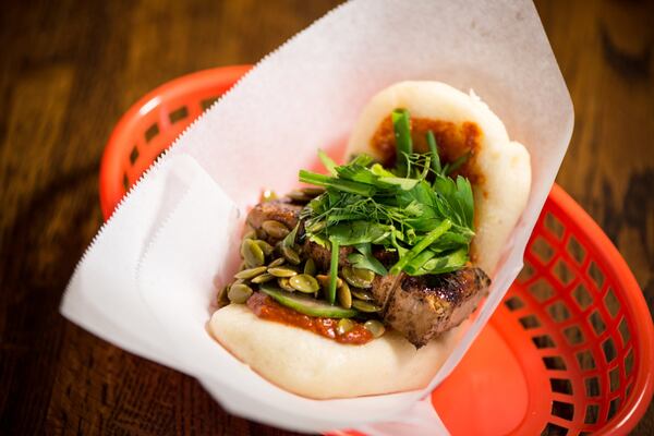 Smoked Tofu Bun with steamed coconut bun, chipotle soy tofu, herbs, gochujang, salted cucumbers, and pepitas. Photo credit- Mia Yakel.