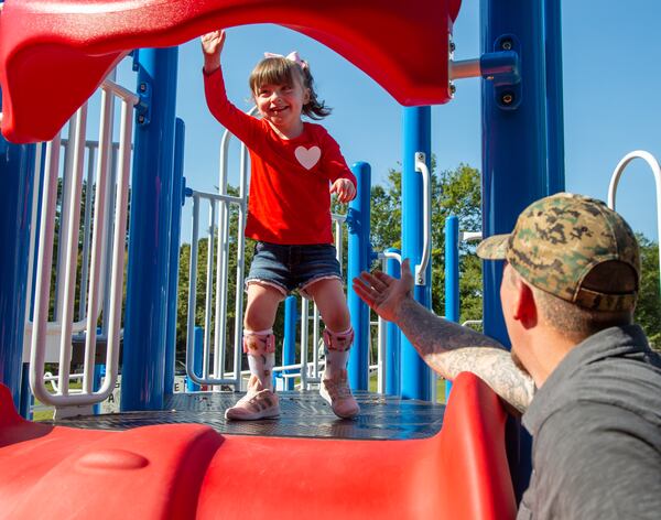 Raven Raines excitedly approaches a slide with her father Mike waiting as she plays on the Alpharetta Elementary School playground with her family. Raven was born almost 5 years ago with a severe congenital heart defect. In her short life, she's survived nine surgeries Ð six of them open-heart surgeries Ð and has spent much of her first three years of life in a hospital. Throughout this ordeal, the family received an outpouring of help from the Alpharetta community. Though still with special needs, Raven is now healthy and will celebrate her 5th birthday Dec. 10. PHIL SKINNER FOR THE ATLANTA JOURNAL-CONSTITUTION.