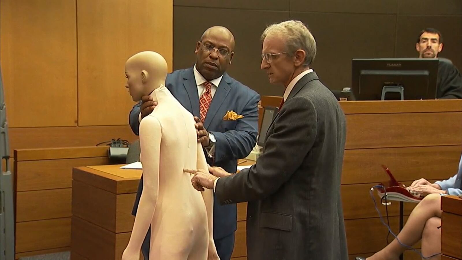 Lead prosecutor Clint Rucker and Dr. Michael Heninger use a mannequin to demonstrate the path of the bullet that killed Dianne McIver. The demonstration was part of the state's examination of Heninger, a Fulton County medical examiner, during the murder trial of Tex McIver on April 10, 2018 at the Fulton County Courthouse. (Channel 2 Action News)