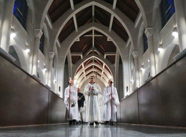 Conyers: Here the monks recess out from concluding Mass during Easter vigil on Sunday April 17, 2014. The Monastery of the Holy Spirit in Conyers has 2,200 acres of beautifully planted gardens and grounds, a visitor's center, museum, lodging for weekend guests, a gothic abbey church, and a gift shop featuring baked goods, fruitcakes, biscotti and fudge, plus bonsai trees cultivated by the monks. It's an unusual feature of the Conyers landscape that has become an attraction for visitors from across the southeast, for those seeking a spiritual retreat and those just seeking a nice outing. For gift-givers it is also a popular holiday destination. The order of Cistercians of the Strict Observance (OCSO), commonly called the Trappists were founded in the 11th century and follow the rule of St. Benedict in their Christian monastic practice. JOHN SPINK/JSPINK@AJC.COM