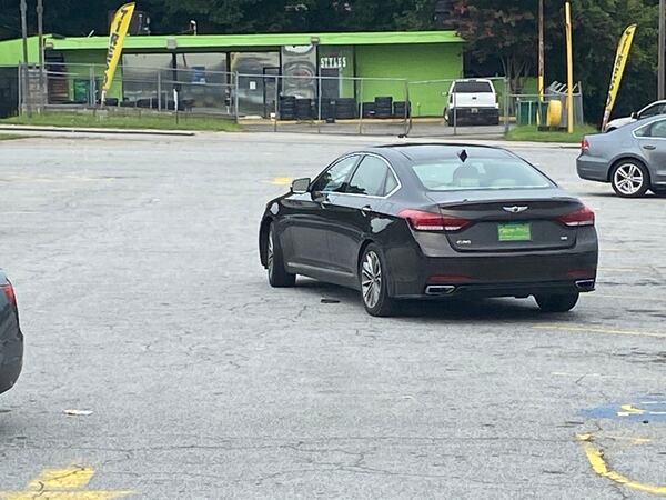 After taking the cash, the woman sped away in a dark gray Hyundai Genesis, police said.