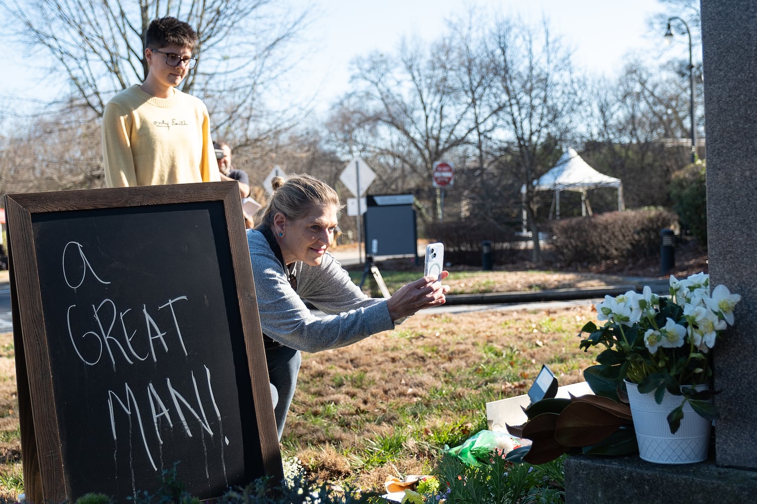 Kristin Lindsey takes a photo of the memorial to  former President Jimmy Carter at the Carter Center in Atlanta on Monday, Dec. 30, 2024 as Sophie Pegnia watches.   Ben Gray for the Atlanta Journal-Constitution