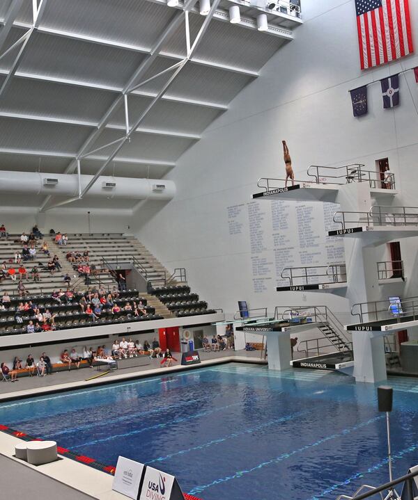 Divers are dwarfed in the arena as they dive from the top platform during the 2017 USA Diving FINA World Championships Senior Men Platform Final at the IUPUI Natatorium, Sunday, May 21, 2017.