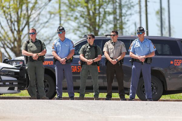 Officers watch as a funeral procession for members of the Hawk family arrives at Unity Baptist Church on Thursday, April 14, 2022, in Newnan, Ga.  The Coweta family was killed during a gun shop robbery.   Branden Camp/For the Atlanta Journal-Constitution