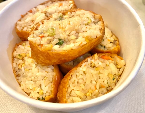 An order of yubuchobap brings fried tofu pockets filled with seasoned rice and vegetables, making for hearty finger food. Ligaya Figueras/ligaya.figueras@ajc.com