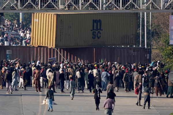 Supporters of imprisoned former premier Imran Khan's Pakistan Tehreek-e-Insaf party, remove shipping container to clear way for their rally demanding Khan's release, in Islamabad, Pakistan, Tuesday, Nov. 26, 2024. (AP Photo/Anjum Naveed)