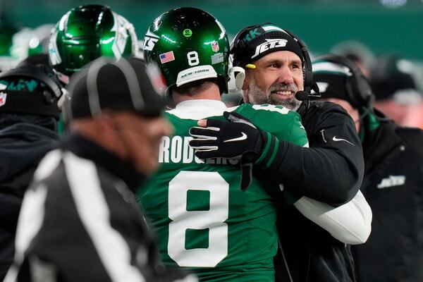 New York Jets quarterback Aaron Rodgers (8) and head coach Jeff Ulbrich, right, hug during the second half of an NFL football game against the Miami Dolphins, Sunday, Jan. 5, 2025, in East Rutherford, N.J. (AP Photo/Seth Wenig)