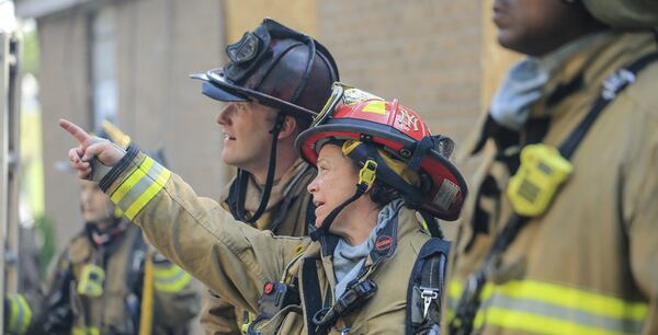 On May 9, 2018, then-Lt. Danny Dwyer (left) and Captain Joette Castronova (center) size up a burning building on Joseph E. Boone Boulevard in Atlanta. JOHN SPINK/JSPINK@AJC.COM