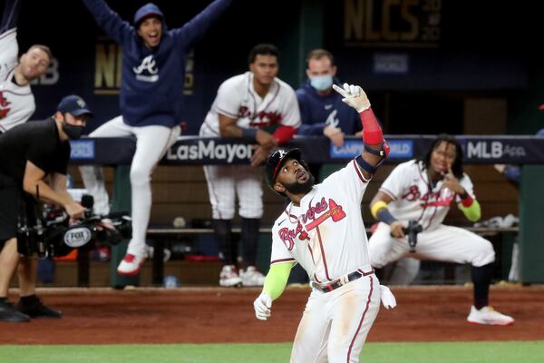 Braves designated hitter Marcell Ozuna celebrates his solo home run with a selfie pose with teammates in the background during Game 4 of the Championship Series against the Los Angeles Dodgers Thursday, Oct. 15, 2020, at Globe Life Field in Arlington, Texas. (Curtis Compton / Curtis.Compton@ajc.com)



