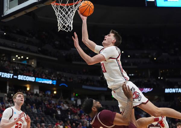 Wisconsin forward Nolan Winter, top, collides with Montana forward Te'Jon Sawyer while shooting during the first half in the first round of the NCAA college basketball tournament Thursday, March 20, 2025, in Denver. (AP Photo/David Zalubowski)