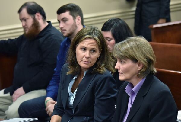 Lawyers for Kelly Gissendaner Beth Wells, foreground left, and Susan Casey, right, confer as children of Kelly Gissendaner, background from left, Brandon Brookshire, Dakota Brookshire and Kayla Gissendaner, wait before a hearing to ask parole board to reconsider Gissendaner's clemency request.