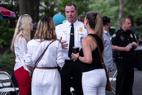 Atlanta Police Deputy Chief Michael O’Connor speaks with residents  Tuesday at National Night Out, reassuring that APD is reviewing camera footage of the recent Piedmont killing,