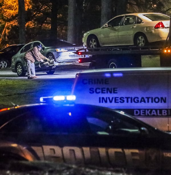 Police and crime scene investigators stand by on March 18, 2019, as two vehicles are towed from the scene where a man was dead and another was in critical condition after a shootout over a woman in DeKalb County, Channel 2 Action News reported. JOHN SPINK/JSPINK@AJC.COM