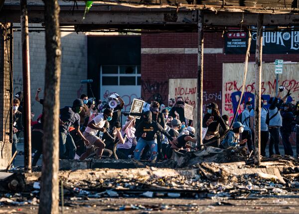 Protesters skirmish with the National Guard near the 3rd Precinct before heading down Lake Street toward the 5th Precinct in Minneapolis on Friday. 