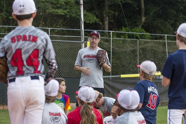 Andy Lipman speaks with members of the Sandy Springs Cyclones Little League team before practice begins at the Morgan Falls Athletic Fields. ALYSSA POINTER / ALYSSA.POINTER@AJC.COM