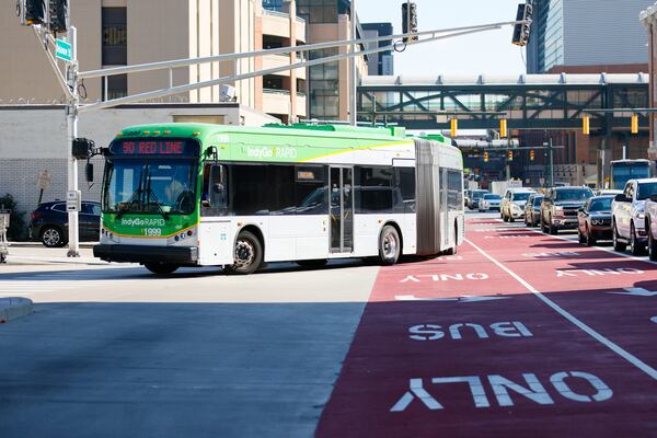 A Red Line rapid transit bus turns toward the Transit Center in downtown Indianapolis using a dedicated bus line. The Transit Center is the central station where all the lines of the IndyGo bus system meet to continue their routes. Tuesday, Aug. 30, 2022. Miguel Martinez / miguel.martinezjimenez@ajc.com 