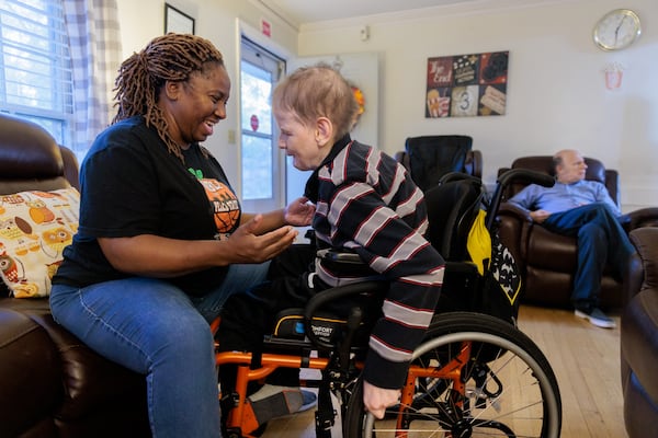 Employee Von Freeman leans in to hug resident Jeffrey Clarke in a group home for people with disabilities in Tucker on Wednesday, November 9, 2022.   (Arvin Temkar / arvin.temkar@ajc.com)