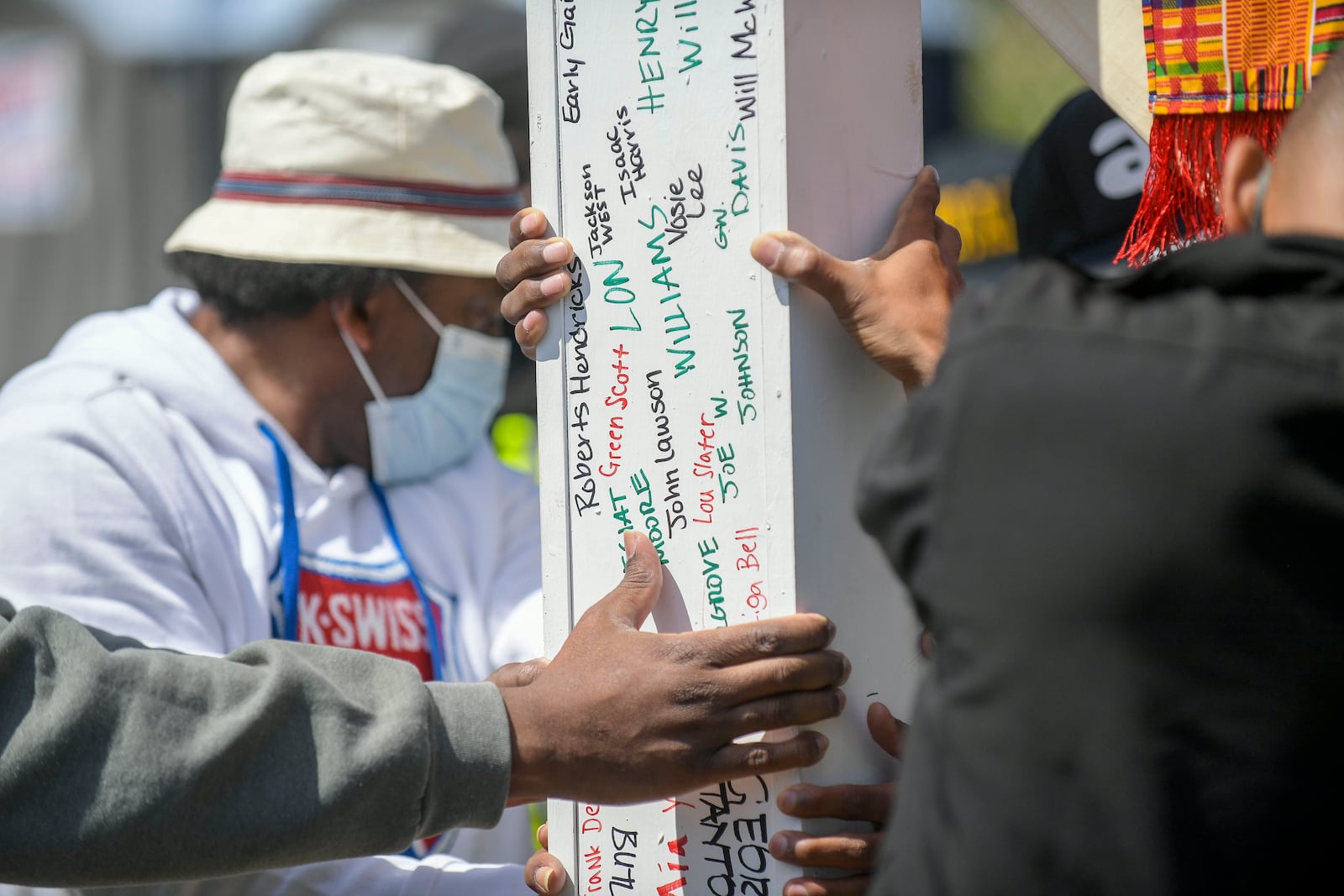 Names of the victims of the Chattahoochee Brick Company are seen on a cross carried by participants of a  sacred event to commemorate the lives lost during a period the company used the convict lease system. The event included a procession, prayers, libations, community testimonials and site consecration Saturday, April 3, 2021, in Atlanta. (Photo: Daniel Varnado for The Atlanta Journal-Constitution)