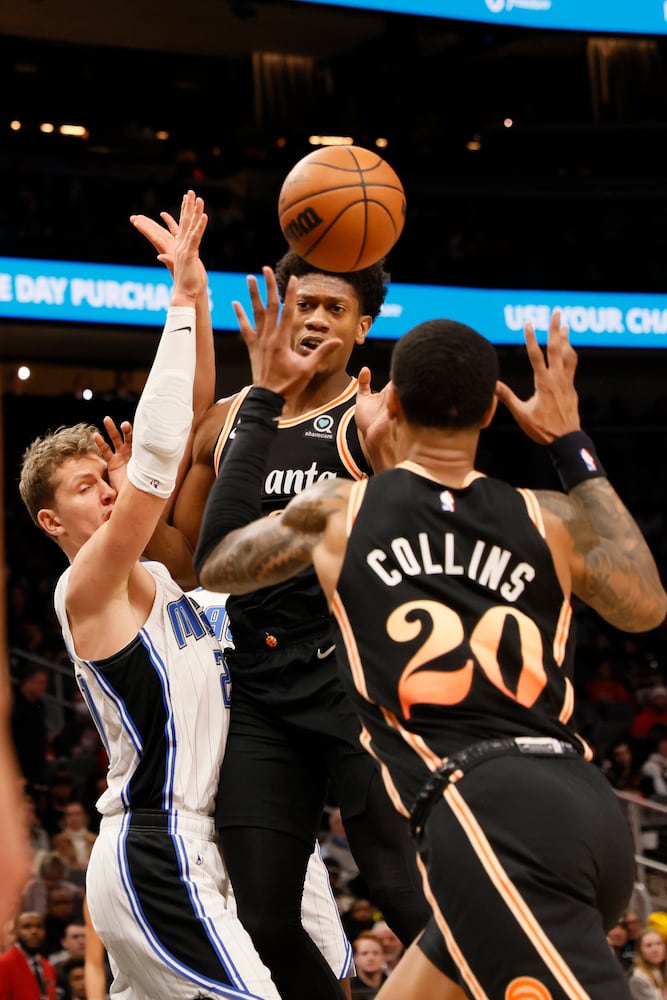 Hawks forward De'Andre Hunter attempts to pass to  forward John Collins during the second half against the Magic on Monday night in Atlanta. (Miguel Martinez / miguel.martinezjimenez@ajc.com)