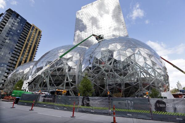 FILE - In this April 27, 2017 file photo, construction continues on three large, glass-covered domes as part of an expansion of the Amazon.com campus in downtown Seattle. Amazon said Thursday, Sept. 7, that it will spend more than $5 billion to build another headquarters in North America to house as many as 50,000 employees. It plans to stay in its sprawling Seattle headquarters and the new space will be “a full equal” of its current home, said founder and CEO Jeff Bezos. (AP Photo/Elaine Thompson)