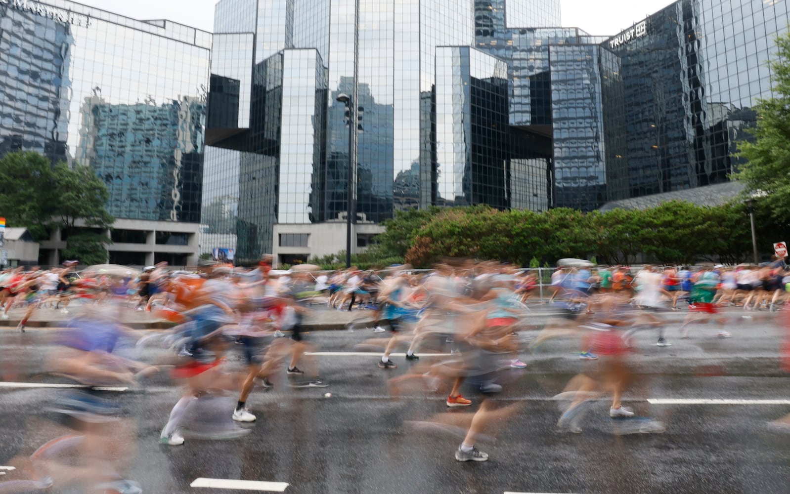 Runners are a blur as they take off up Peachtree Street during the 54th running of the Atlanta Journal-Constitution Peachtree Road Race in Atlanta on Tuesday, July 4th, 2023.   (Miguel Martinez / Miguel.Martinezjimenez@ajc.com)