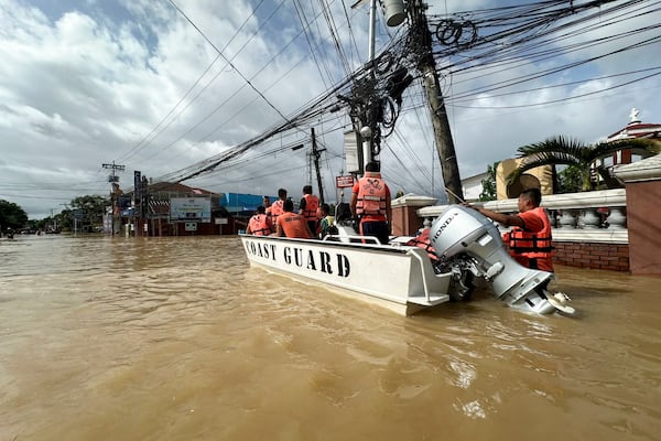 In this photo provided by the Philippine Coast Guard, rescuers ride a boat around the flooded town of Nabua, Camarines Sur, Philippines on Friday Oct. 25, 2024. (Philippine Coast Guard via AP)