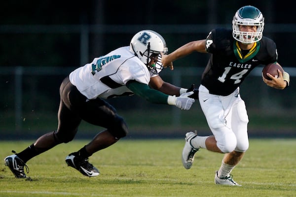 Collins Hill's Taylor Heinicke (14) pushes away Roswell's Julian Boyd (84) during first half action.