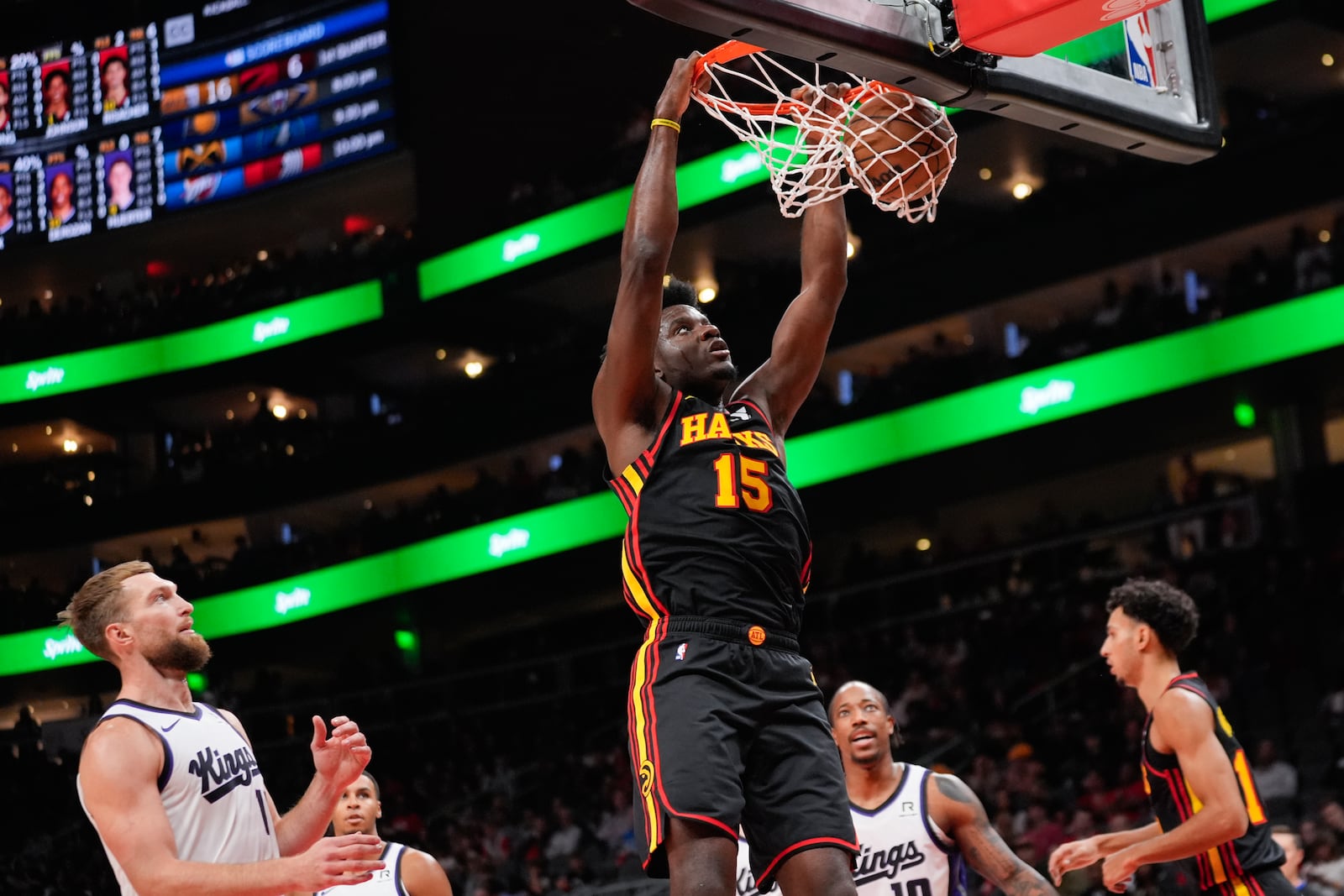 Atlanta Hawks center Clint Capela (15) scores as Sacramento Kings forward Domantas Sabonis (11) looks on during the first half of an NBA basketball game, Friday, Nov. 1, 2024, in Atlanta. (AP Photo/ John Bazemore )