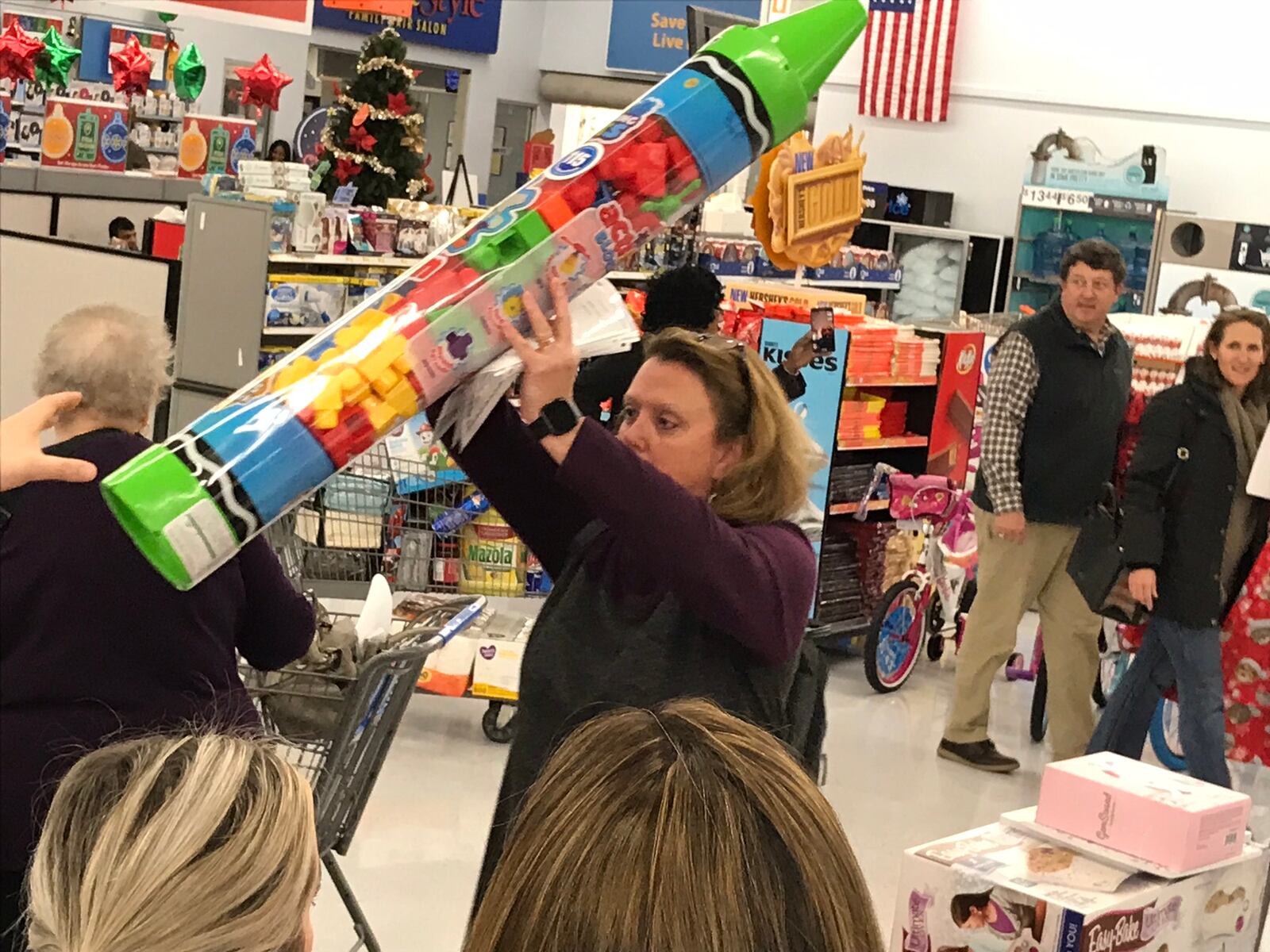 Chrys Bruno hoists a gift she purchased or a Clark's Kids foster child. She has been donating for five years and this year, she provided gifts for five different kids. CREDIT: Rodney Ho/rho@ajc.com