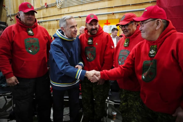 Canada Prime Minister Mark Carney meets with members of the Canadian Rangers after making an announcement at a Canadian Armed Forces forward-operating location in Iqaluit, Nunavut, on Tuesday, March 18, 2025. (Sean Kilpatrick/The Canadian Press via AP)