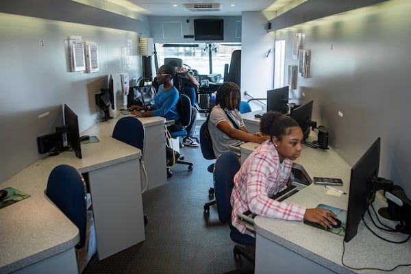 Job seekers work on their online applications in a mobile career center at a job fair hosted by Goodwill Career Center in Atlanta on Tuesday, July 9, 2024.  (Ziyu Julian Zhu / AJC)