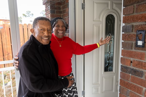 George and Dorothy Williams pose for a portrait in front of their newly rebuilt home in Atlanta on Wednesday, December 4, 2024. The pair were displaced after falling victim to a home repair scam, but are back after filmmaker Tyler Perry offered to pay for construction. (Arvin Temkar / AJC)