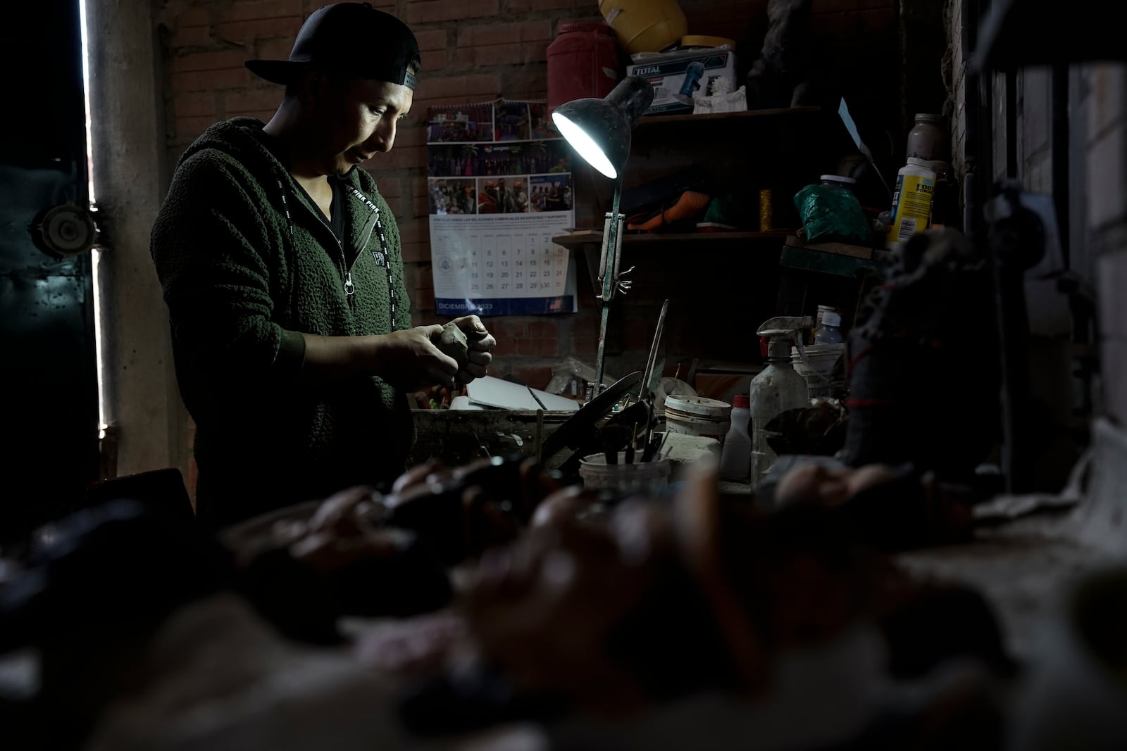 Artisan William Luna creates a mask of a specific person to adorn a sweet bread, traditional for Day of the Dead celebrations, called tantawawa, in La Paz, Bolivia, Thursday, Oct. 31, 2024. (AP Photo/Freddy Barragan)